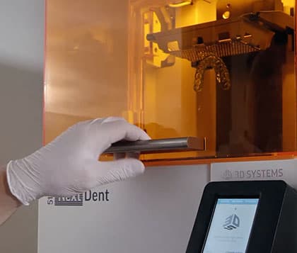 Человек, использующий 3D-принтер в стоматологической клинике