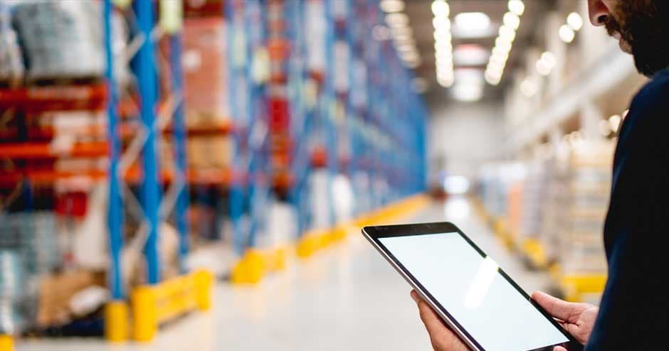 warehouse setting man holding tablet in foreground