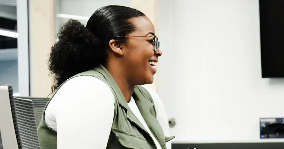 a colleague sitting at a table smiling