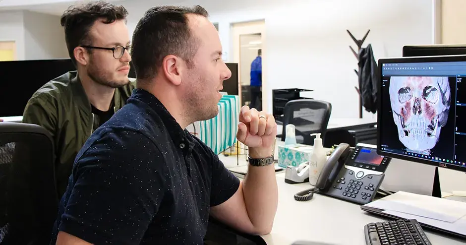 2 colleagues at a desktop