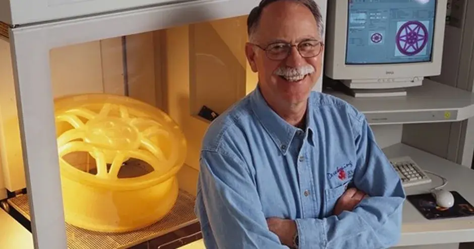 Chuck Hull standing in front of the first SLA printer