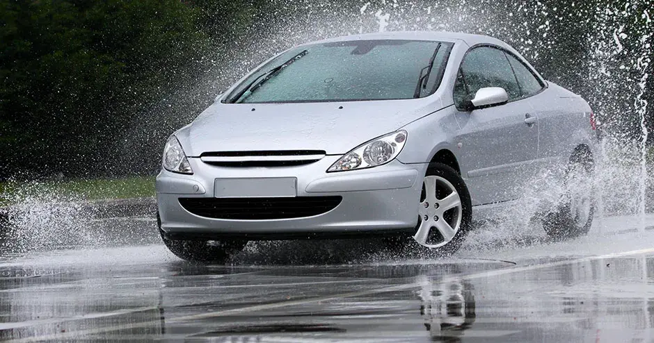 A car driving through a puddle and creating a giant splash