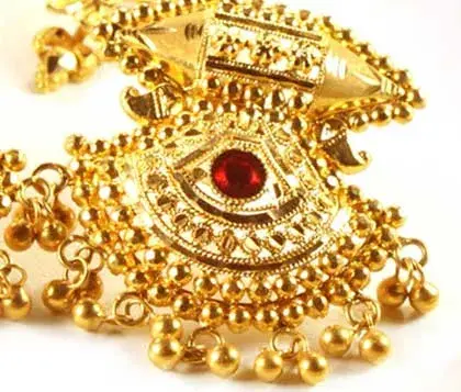 intricate gold earring design with ruby set in the middle