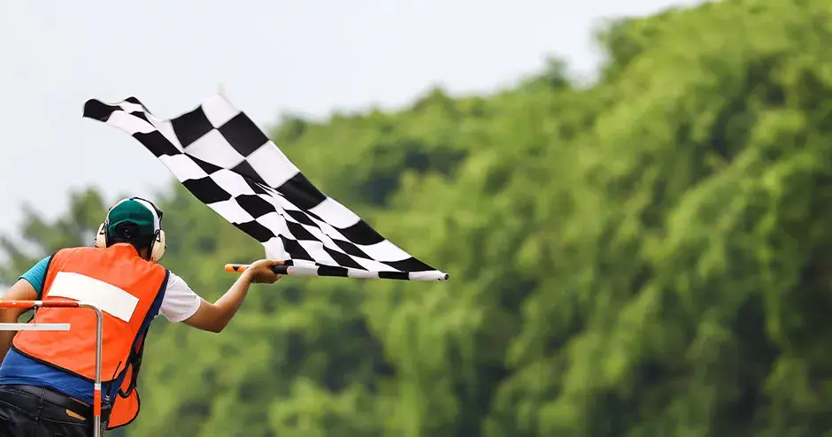 Back view of man holding checkered race flag