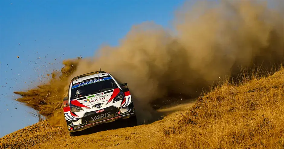 car racing leaving a huge dust cloud in its wake