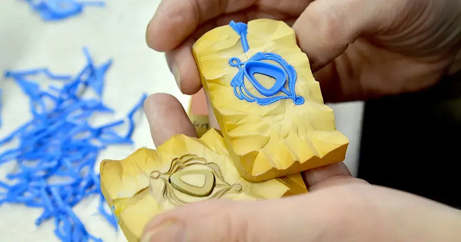 blue wax pendant with rounded triangular bezel in yellow rubber mold