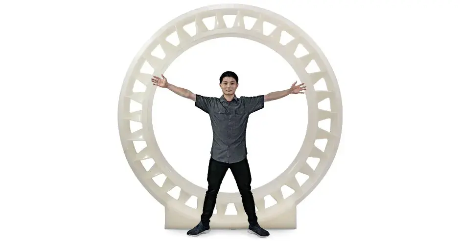 a man standing inside of a 3D printed stator, showing that the scale is larger than him