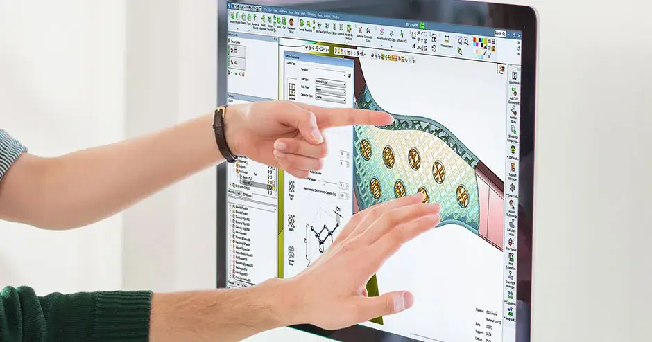 2 people pointing to a computer monitor