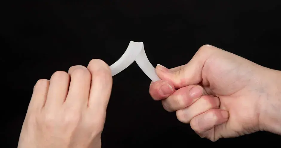 A person twisting a 3D printed part made from DuraForm PAx Natural 