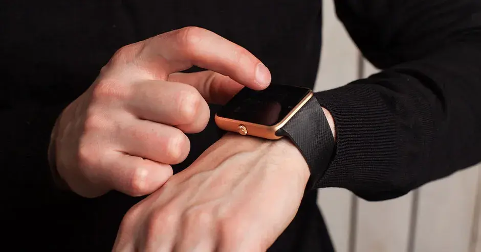 a man wearing a watch and pointing at the features of the watch