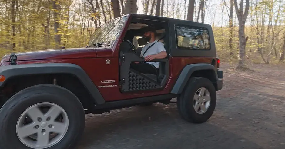 A man sitting in a Wrangler, which has parts made from an Atlas H 3D printer