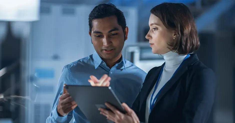 2 people collaborating on a tablet in an industrial setting