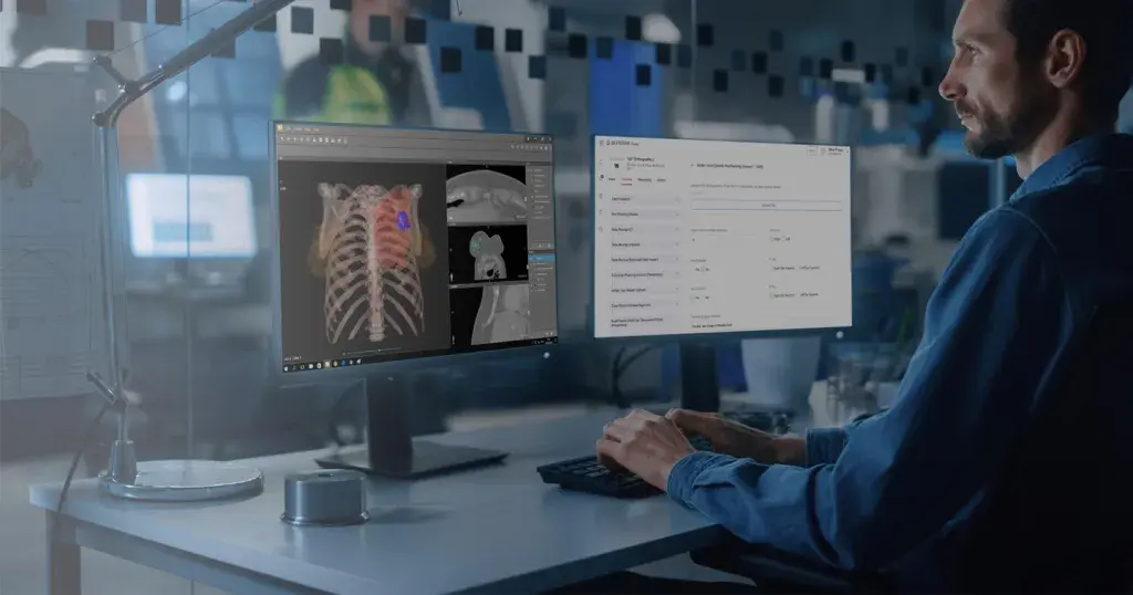 Man looking at two computer monitors