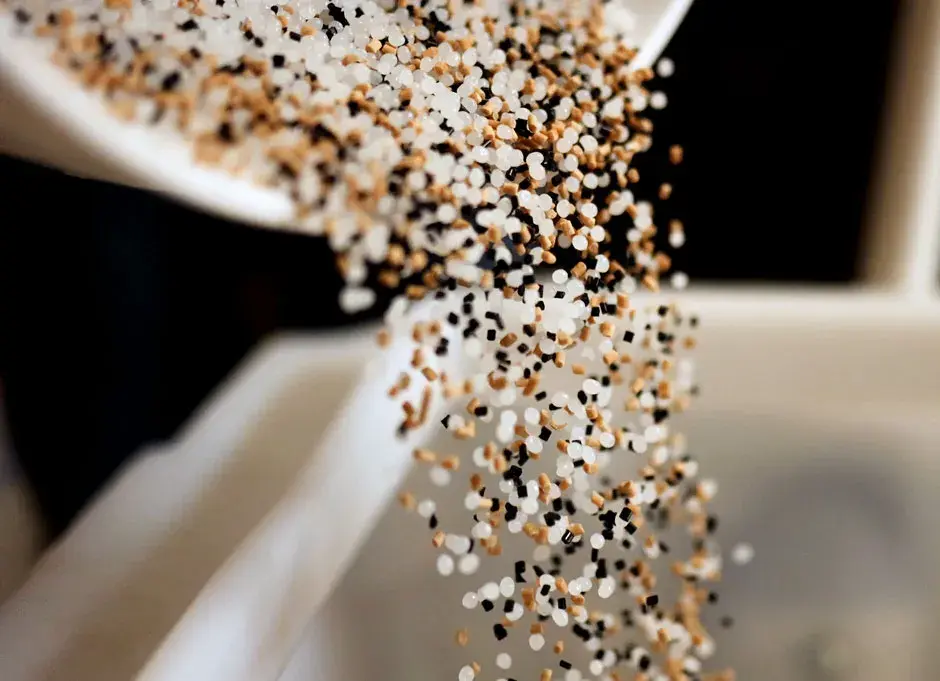 Plastic pellets being poured into a 3D printer
