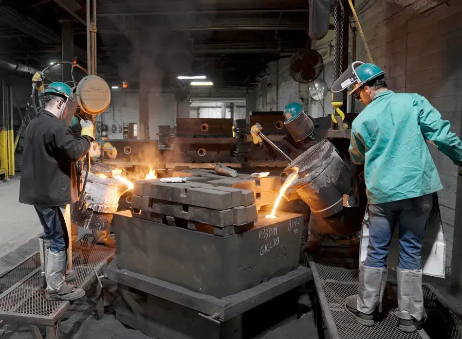 Astech employees pour molten steel into a sand mold produced with 3D printed patterns. 