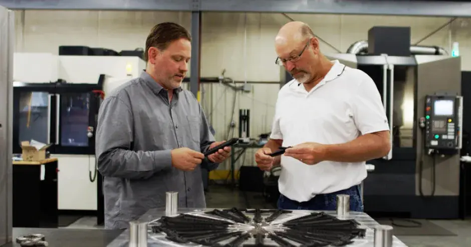 Allegiance Mold, LLC president and CEO Ted Stender and senior mold designer Dave VanDeLaare inspecting final parts from plastic injection mold designed and manufactured using Cimatron®